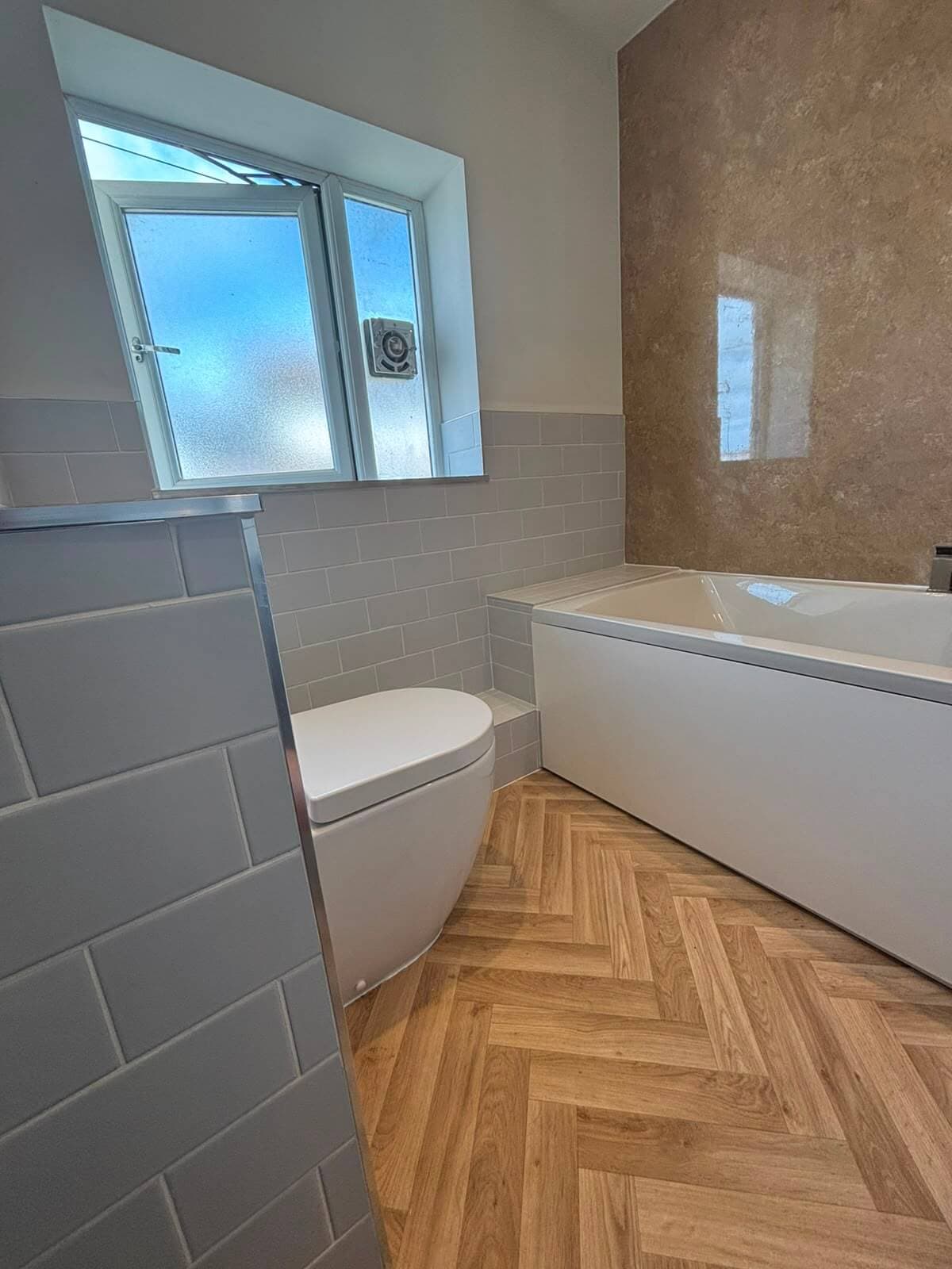 Bathroom installation in Cardiff with a bath and glass shower screen, completed by JM Plumbing Services